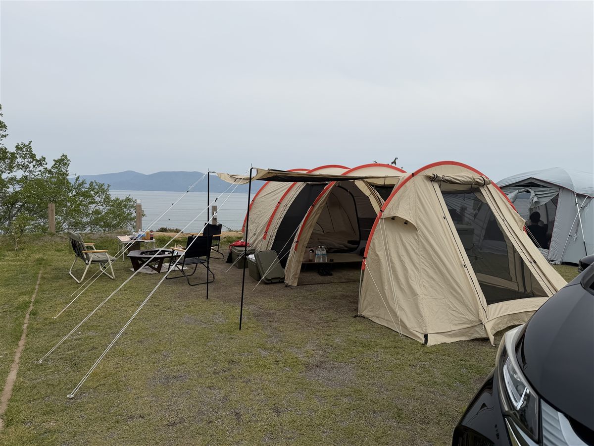 海沿いの芝生サイトに車を横付けして設営した様子